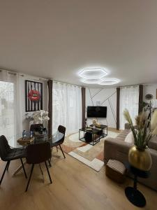 a living room with a couch and a table at Escale Cosy à Villeneuve in Villeneuve-la-Garenne