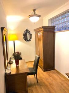 a room with a desk and a cabinet and a lamp at Apartamente Arcul de Triumf in Bucharest