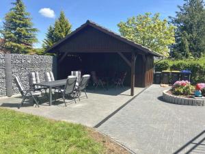 a patio with a table and chairs and a building at FeWo Wolfsbau ID 16290-9 in Kargow