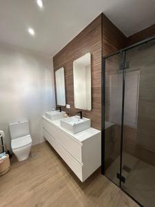 a bathroom with two sinks and a shower at Center Luxury Chalet Mazagón in Mazagón +11 photos