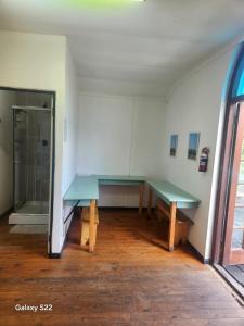 a room with a green table and a glass door at Forest Gate Backpackers in Plettenberg Bay