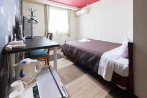 Select Inn Fujisan Gotemba في غوتيمبا: غرفه فندقيه بسرير وطاولة مع صحون