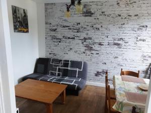 a living room with a couch and a brick wall at L atelier du pain in Mesvres