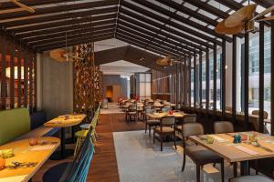 a restaurant with wooden ceilings and tables and chairs at Centara Grand Hotel Osaka in Osaka