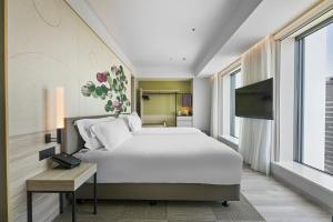 a hotel room with a bed and a television at Centara Grand Hotel Osaka in Osaka