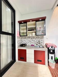 a kitchen with red and white cabinets in a room at Athara Residence in Tlekung