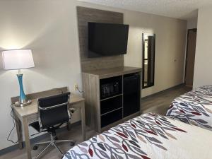 a hotel room with a bed and a desk and a television at Red Roof Inn & Suites Hammond, IN in Hammond