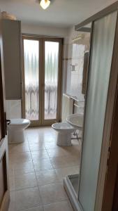 a bathroom with three sinks and two toilets at Hotel Orsa Maggiore in Falcade +40 photos