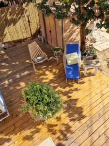 a wooden deck with a chair and a bench at בין צבעי החול in Sappir +8 photos