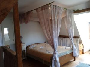 a bedroom with a canopy bed with curtains at Gîte de Bontemps in Saint-Vincent-de-Cosse