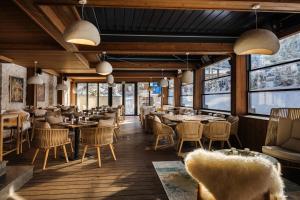 a restaurant with tables and chairs and windows at Flora Boutique Hotel in Borovets