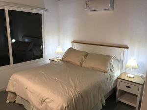 a bedroom with a bed with two night stands and two lamps at Sur in Barra de Portezuelo