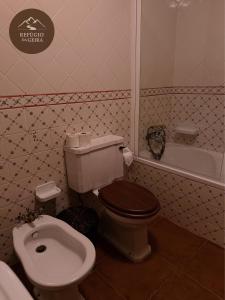 a bathroom with a toilet and a bath tub at Refúgio da Geira in Campo do Gerês +5 photos