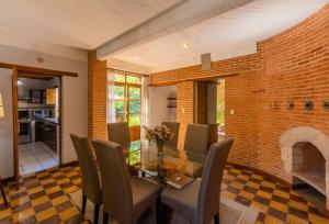 a dining room with a brick wall and a glass table and chairs at Casa Historica Atitlán in Panajachel
