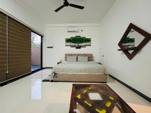 a bedroom with a bed and a ceiling fan at Villa Sara in Balapitiya