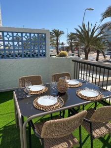 a blue table with plates and glasses on a patio at Isabella in Roquetas de Mar