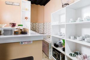 a kitchen with white shelves filled with dishes at Fast Hous Syariah Bogor Mitra RedDoorz in Bogor