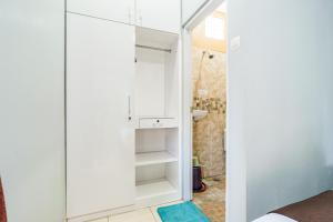 a small bathroom with white cabinets and a sink at Fast Hous Syariah Bogor Mitra RedDoorz in Bogor +19 photos