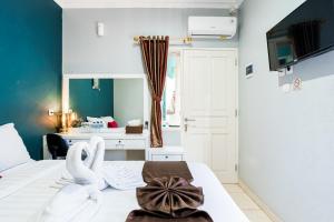 a bedroom with a bed with swans on it at Fast Hous Syariah Bogor Mitra RedDoorz in Bogor