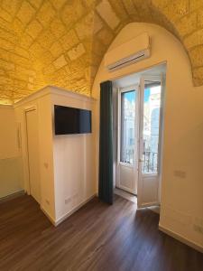 a living room with a tv and a window at La Neviera Apulia Rooms in Altamura +15 photos