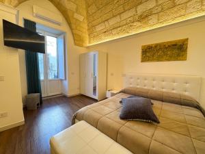 a bedroom with a large bed and a large window at La Neviera Apulia Rooms in Altamura