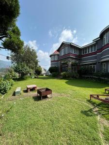a large building with a picnic table in the yard at Solan Retreat in Solan