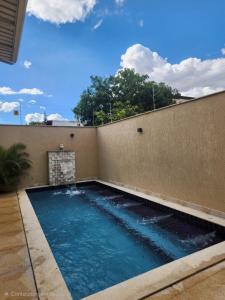 a swimming pool attached to a building with a wall at Casa 4 quartos com piscina em Aparecida de Goiania in Aparecida de Goiânia