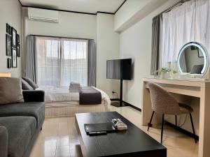 a living room with a couch and a bed at Lion Heiwa Odori in Hiroshima