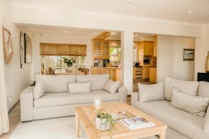 a living room with two couches and a table at House Olive in De Kelders