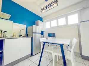 a kitchen with a table and some white chairs at Bel appartement à Royat in Royat