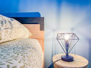 a lamp on a table next to a bed at Bel appartement à Royat in Royat