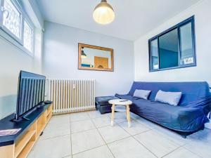a living room with a blue couch and a tv at Bel appartement à Royat in Royat