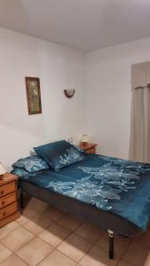a bedroom with a bed with a blue comforter at Medano House Ocean Beach in El Médano
