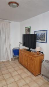 a flat screen tv sitting on top of a wooden cabinet at Medano House Ocean Beach in El Médano