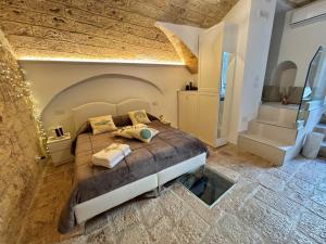 a bedroom with a large bed in a brick wall at La Neviera Apulia Rooms in Altamura