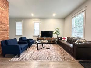 a living room with a couch and chairs and a tv at Trendy Home Spacious Backyard Historic Walkerville in Windsor