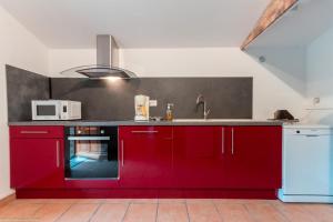a kitchen with red cabinets and a sink at Ecluse d'Aiguilly in Alluy