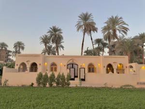 a house with palm trees in the background at Talia gust house in Al Aqālitah