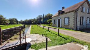 a building next to a canal next to a house at Ecluse d'Aiguilly in Alluy