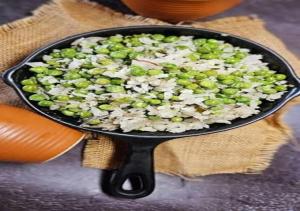 a pan filled with rice and peas on a table at The Trishul Stay in Varanasi