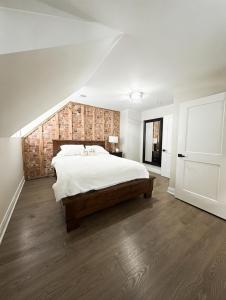 a bedroom with a large bed with a wooden wall at Trendy Home Spacious Backyard Historic Walkerville in Windsor