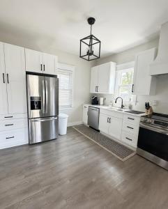 a kitchen with white cabinets and a stainless steel refrigerator at Trendy Home Spacious Backyard Historic Walkerville in Windsor