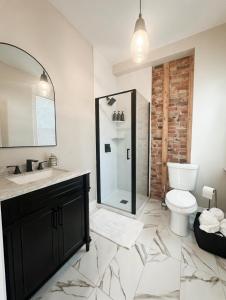 a bathroom with a shower and a toilet and a sink at Trendy Home Spacious Backyard Historic Walkerville in Windsor +9 photos