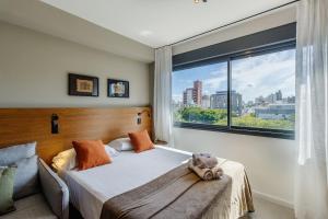 a bedroom with a bed and a large window at Skyline Parque Moinhos in Porto Alegre +133 photos