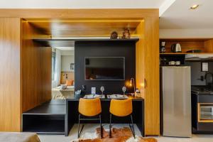 a kitchen with a table and two yellow chairs at Skyline Parque Moinhos in Porto Alegre