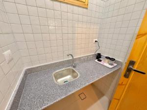 a kitchen counter with a sink in a bathroom at Talia gust house in Al Aqālitah