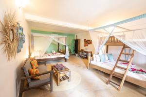 a bedroom with two bunk beds and a living room at Reef & Beach Resort - Spa Jambiani in Jambiani +59 photos