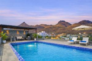 a swimming pool with a view of the mountains at The Royal Galaxy - Hotel in Fateh Sagar Rd in Bedla