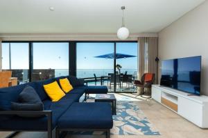 a living room with a blue couch with yellow pillows at Elísio do Mar by LovelyStay in Prazeres