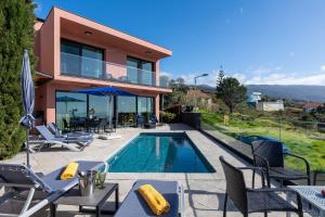 a villa with a swimming pool and a house at Elísio do Mar by LovelyStay in Prazeres
